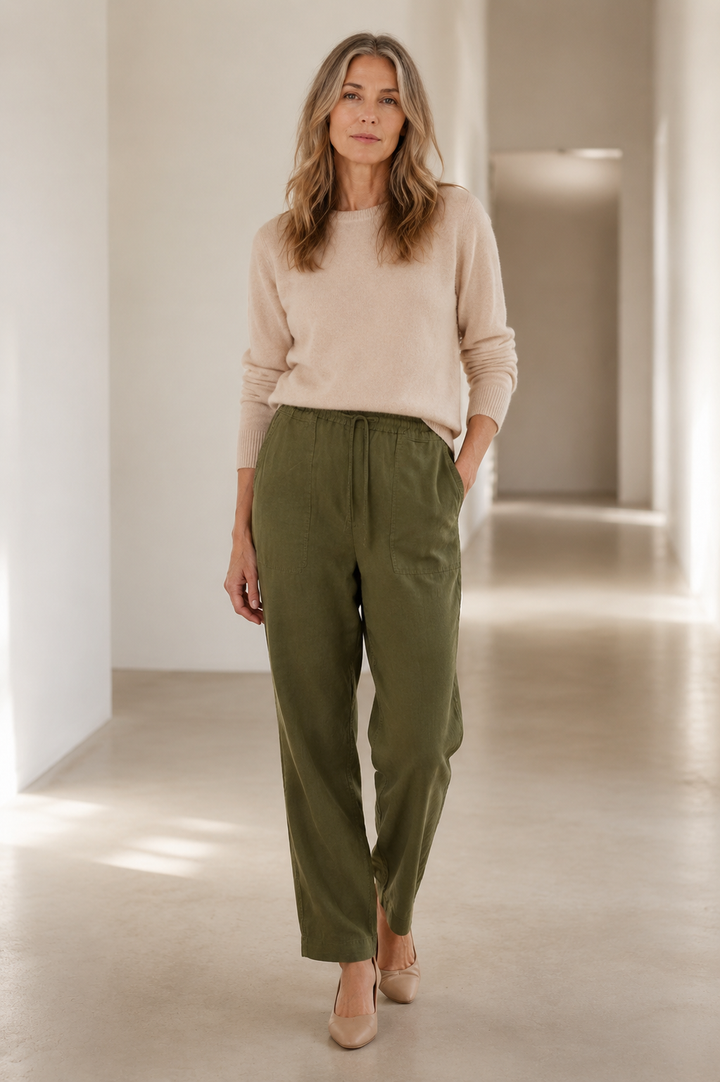 Dark green High Waist Cotton Denim Jeans on a mature woman in an empty hallway