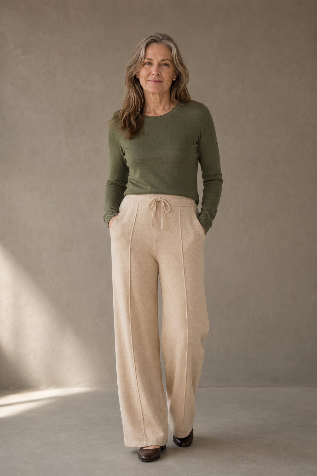 Khaki Merino Wool Wide Leg Trousers on a mature woman against a charcoal taupe wall
