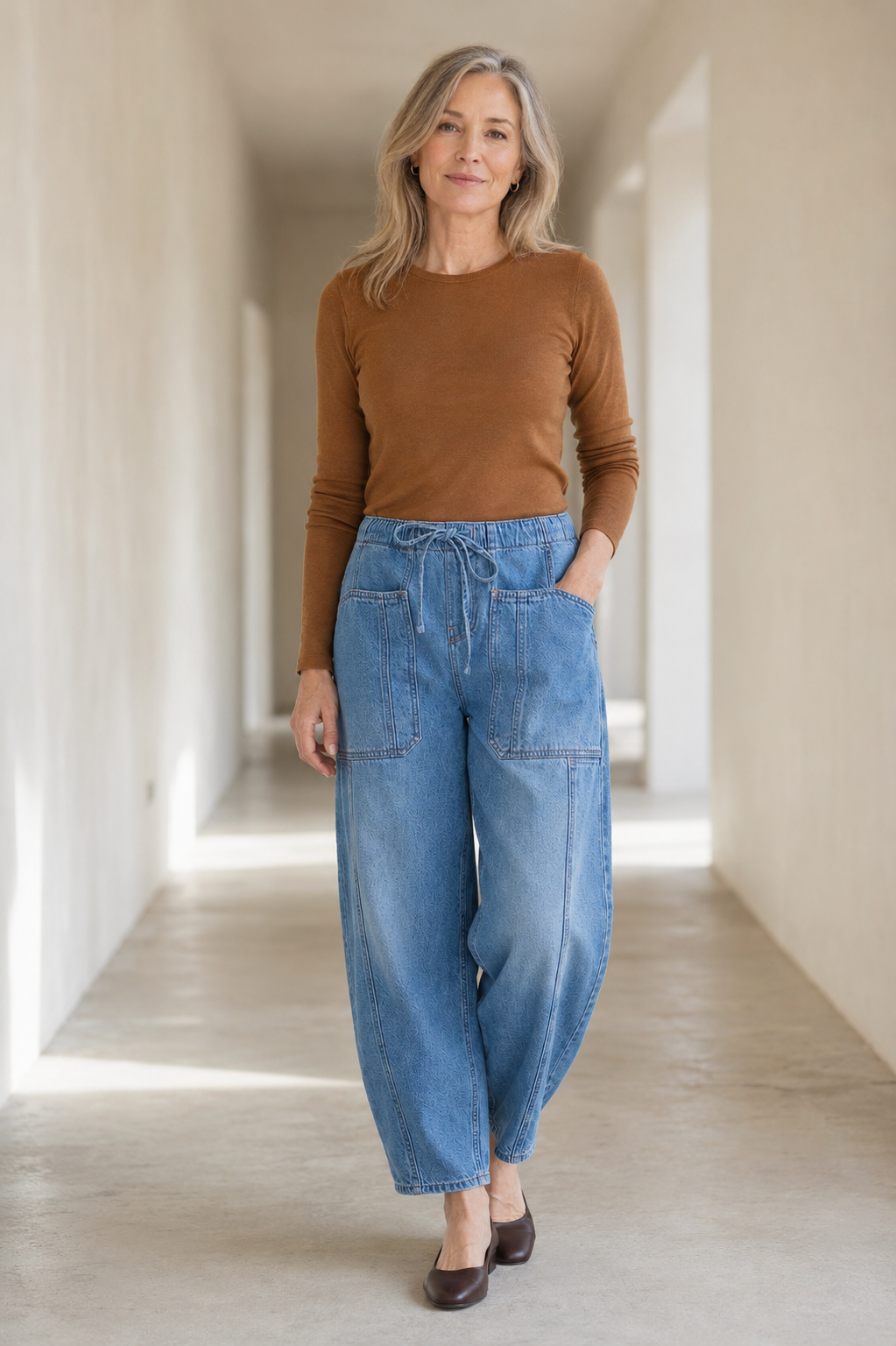 Light blue Relaxed Cotton Denim Jeans on a mature woman in an empty hallway