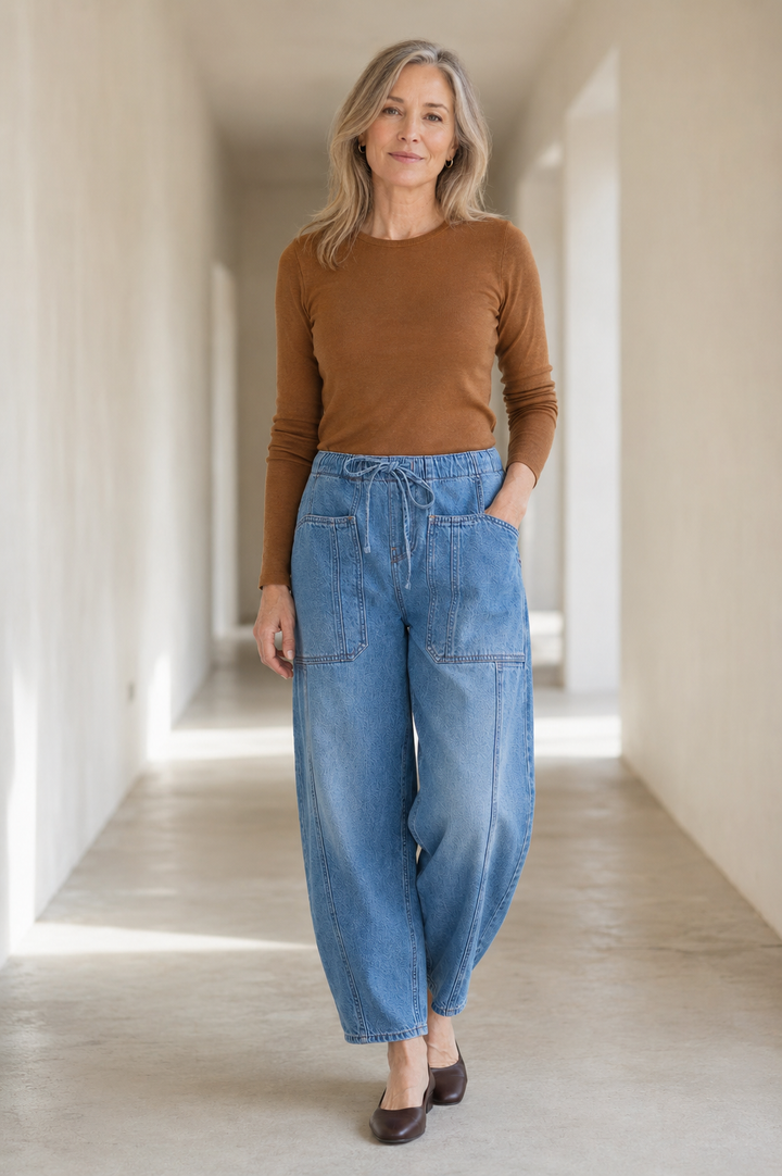 Light blue Relaxed Cotton Denim Jeans on a mature woman in an empty hallway