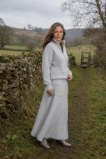 Angela light grey brushed knit sweater and skirt set beside a country stone wall