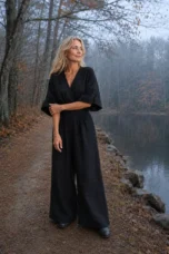 Felicite black linen jumpsuit on a misty autumn lakeside path