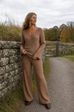 Flore light brown dense knit set beside an autumn stone wall