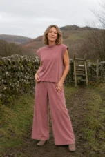 Francoise pink sleeveless wide leg matching set beside a countryside stone wall