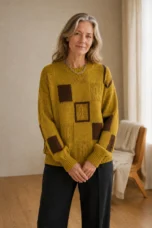 Grace mustard-yellow geometric knit sweater with brown square motifs, main product model with hands loosely crossed