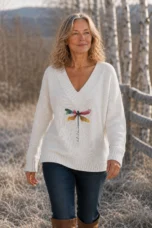 Hermeline dragonfly print V-neck knit in white, outdoor editorial photograph