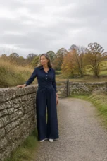 Jacquette navy cropped wrap top and wide trousers beside an autumn stone wall