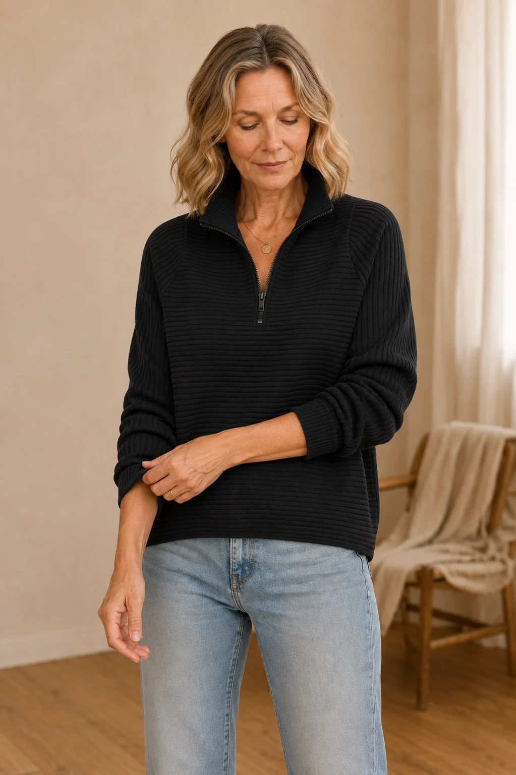 Julie black ribbed half-zip sweatshirt on the main product model, adjusting the opposite cuff
