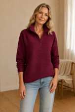 Julie burgundy ribbed half-zip sweatshirt on the main product model, arms relaxed with her head slightly tilted