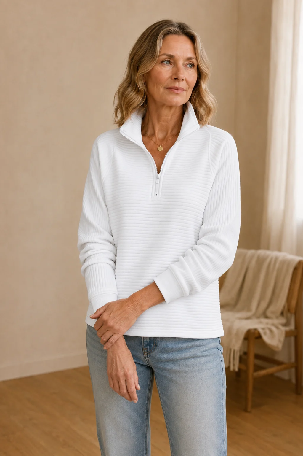 Julie white ribbed half-zip sweatshirt on the main product model, gently holding her opposite wrist