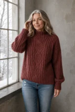 June burgundy cable-knit sweater in its muted reddish-brown shade on the main product model, gently touching her hair