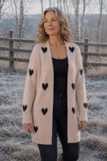 Rosa Knitted-In Heart Cardigan in Apricot, outdoor editorial photograph